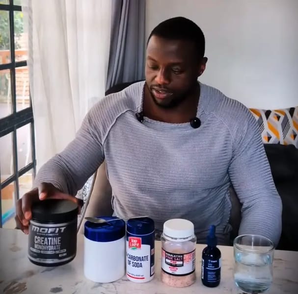 Gachau Njoroge holding creatine container as part of his preworkout stack