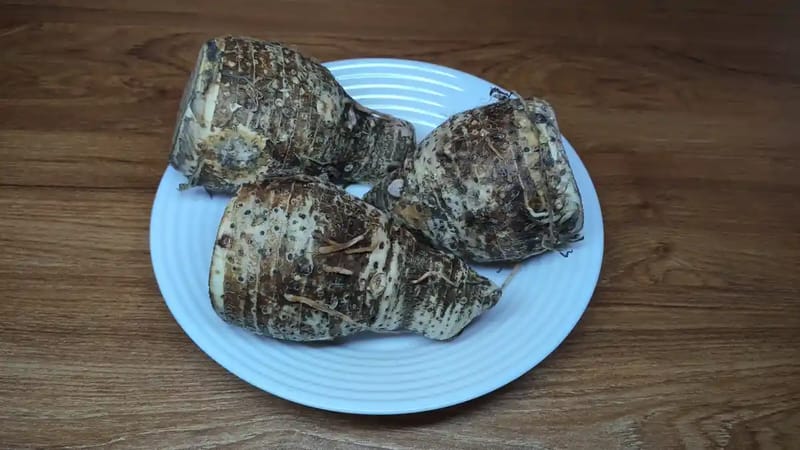 Raw Nduma taro root showing brown fibrous skin and white interior as found in Kenyan markets